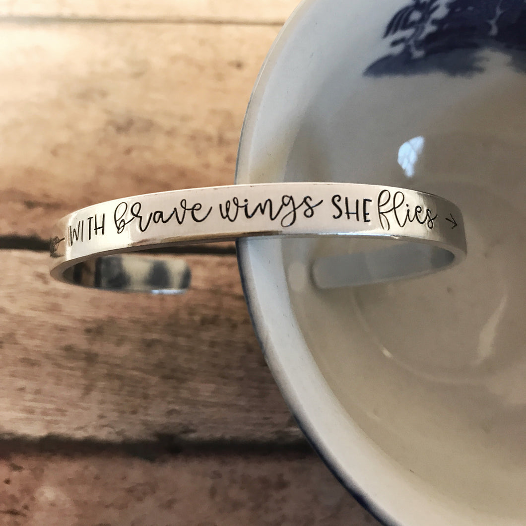“With brave wings she flies” cuff